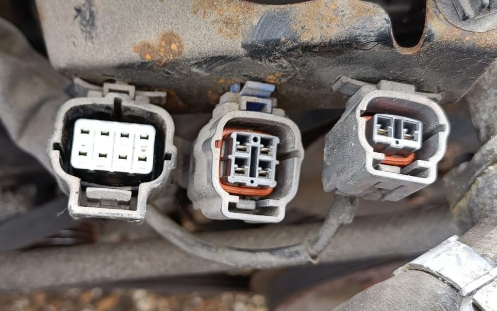 Image of connectors at front of engine near thermostat housing.
