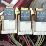 Image of relays locted between O/S wing and engine bay fuse box
