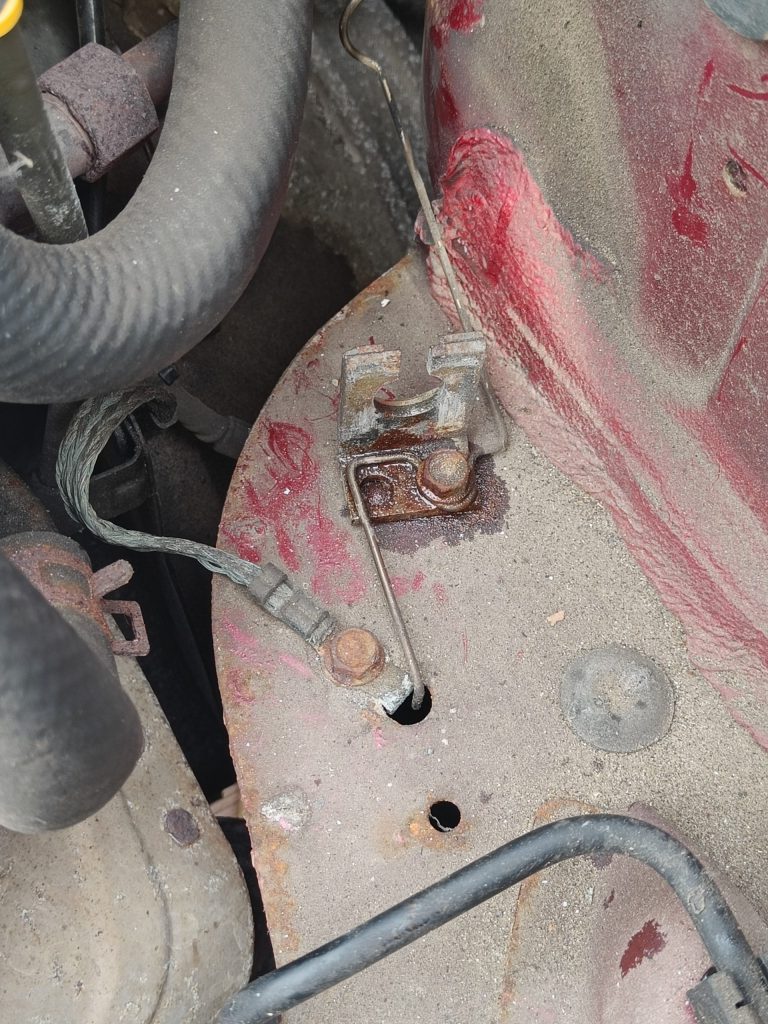 Image of clutch rigid pipe to rubber pipe connecting bracket at rear of engine bay.