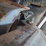 Image of cut exhaust silencer hanger at rear of car.