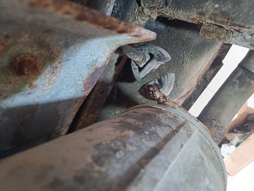 Image of cut exhaust silencer hanger at rear of car.