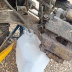 Image of draining the brake fluid into a plastic container.