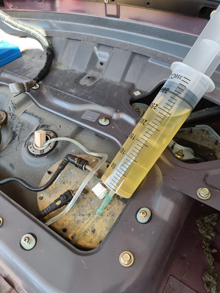 Image of syringing out the fuel tank through the EVAP connection.