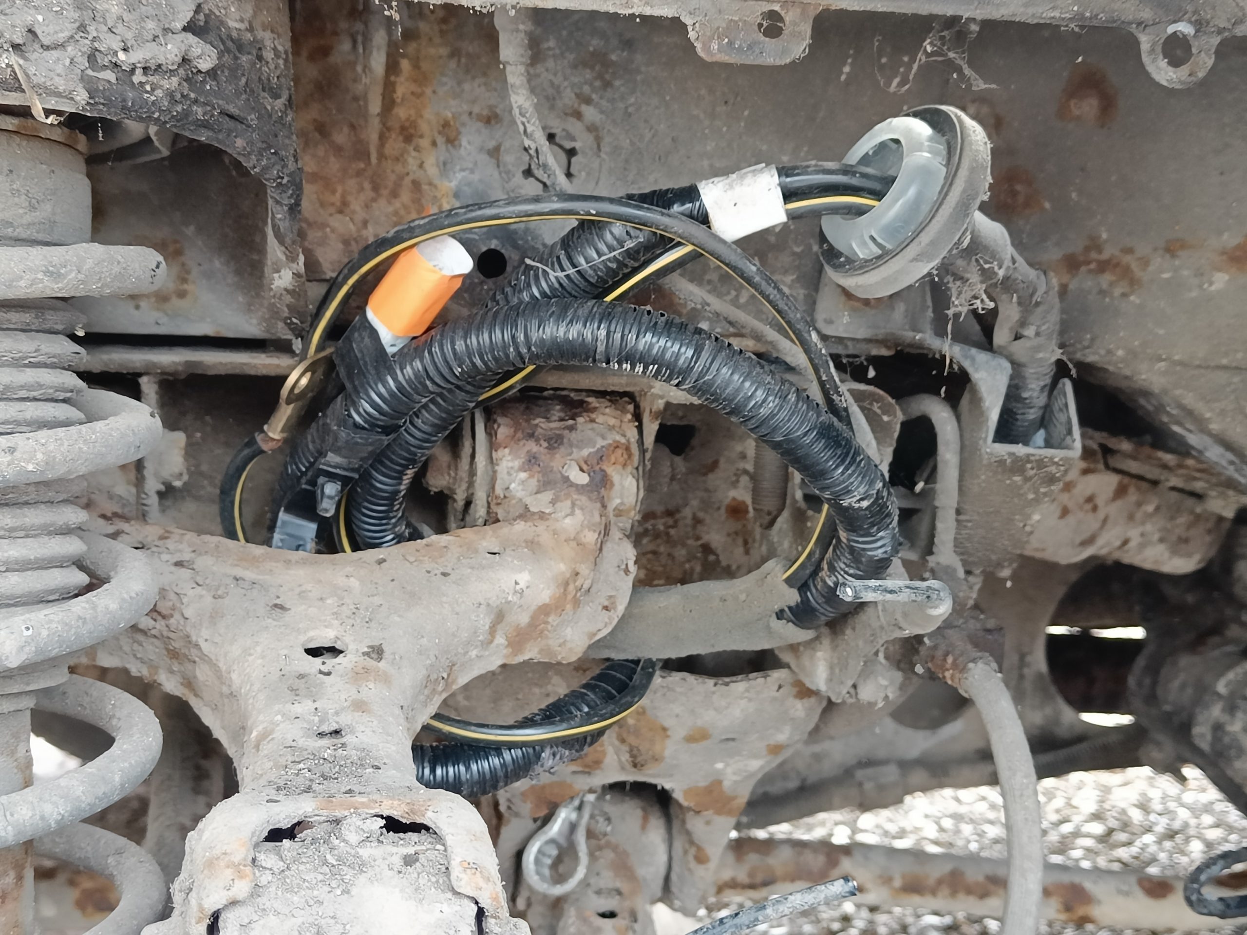 Image of the battery cable pushed through into wheel arch and tidied out of the way