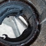 Image of screwdriver used start to peel back the edge of the diff bush prior to knocking out.