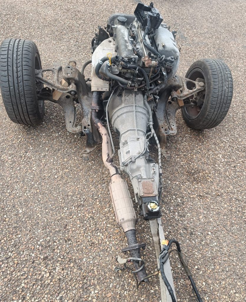 Image of engine, gearbox, front subframe and PPF after being rolled out from the body shell.