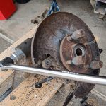 Image of lower rear wishbone bolt being initially rotated using a breaker bar and penetrating oil.