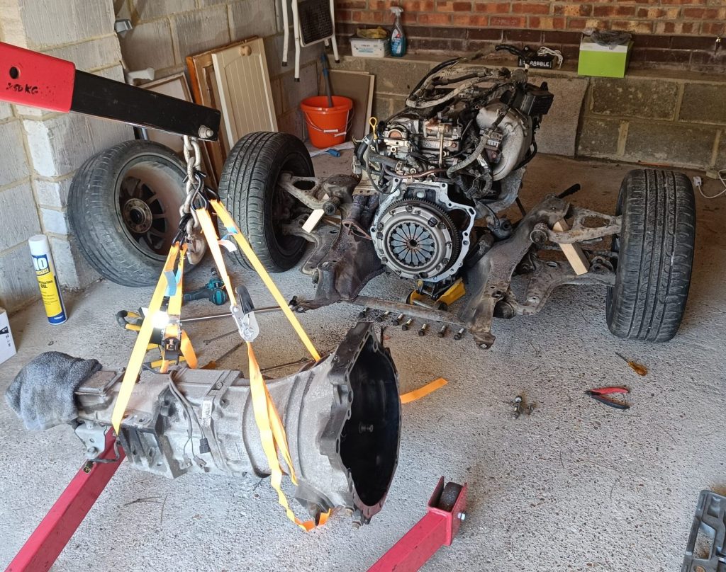 Image of gearbox lifted away from engine using engine hoist.