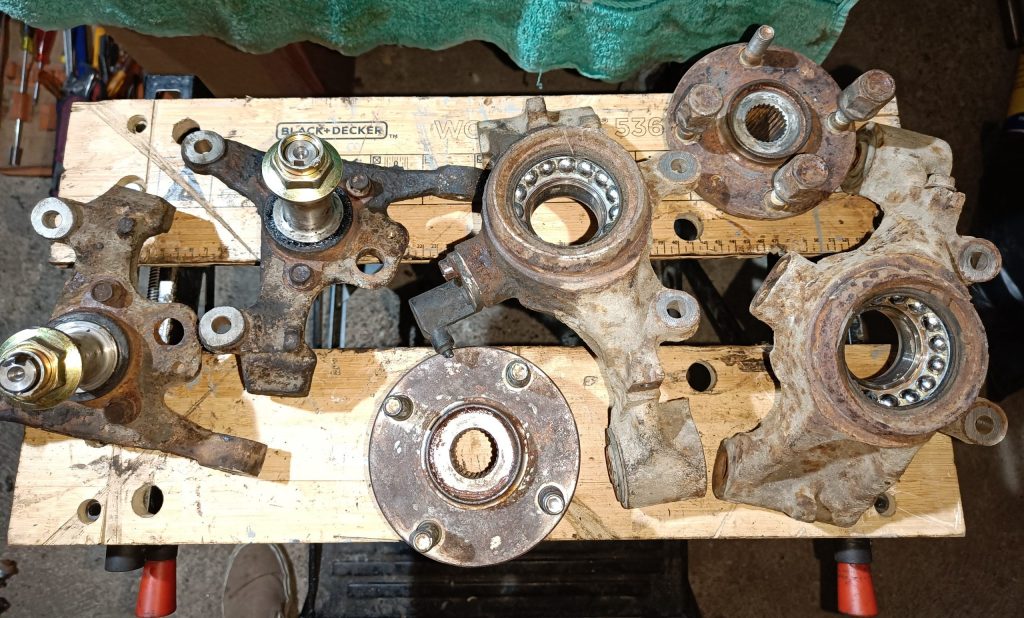 Image of front and rear hubs / upright assemblies being readied for paint and new bearings.