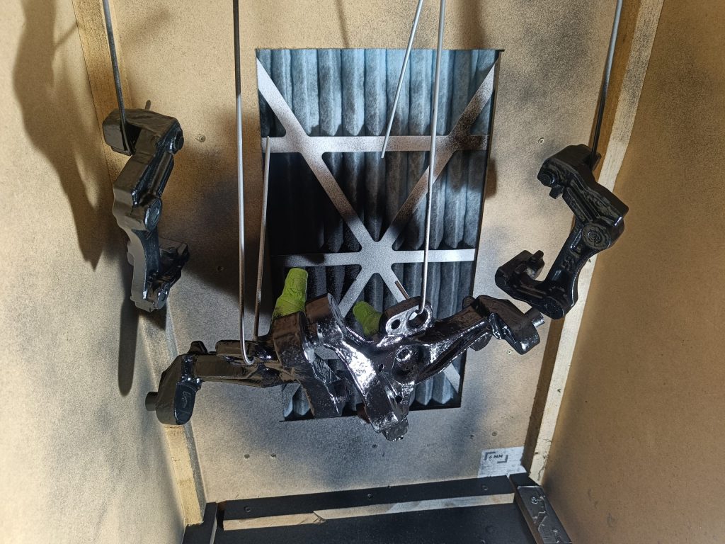 Image of inside of home brew spray booth with painted items drying.