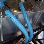 Image of flexible fuel line routing from tank towards fuel filter and rigid fuel lines