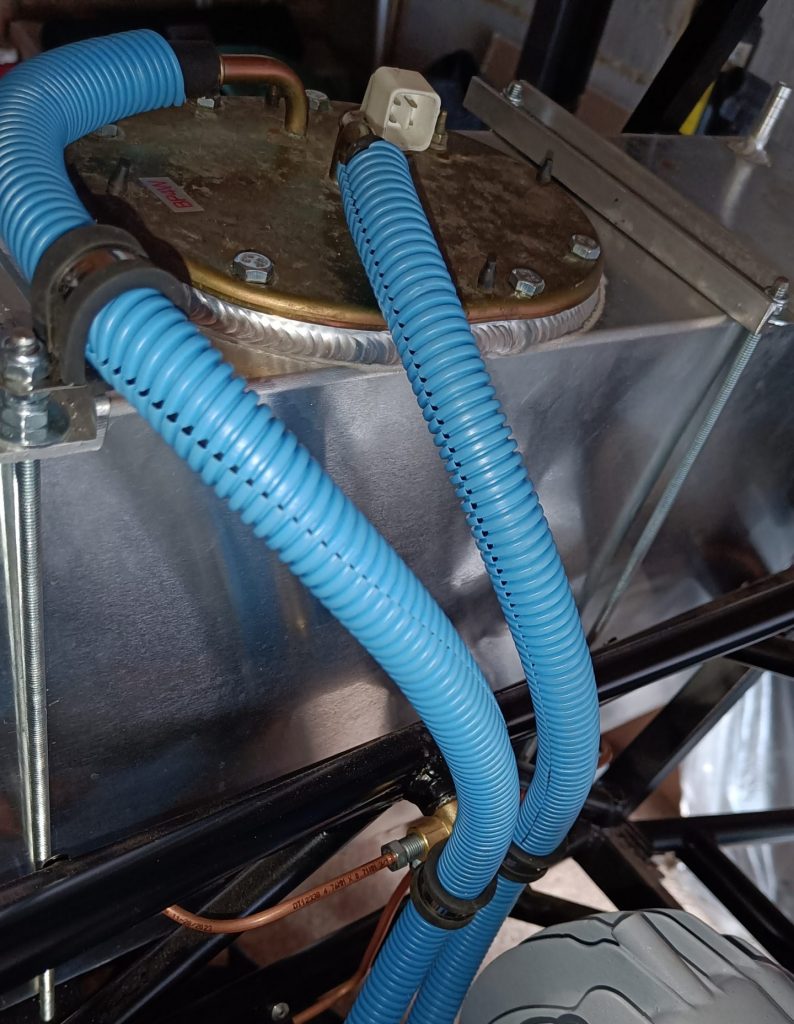 Image of flexible fuel line routing from tank towards fuel filter and rigid fuel lines