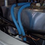 Image of flexible fuel line routing from tank towards fuel filter and rigid fuel lines