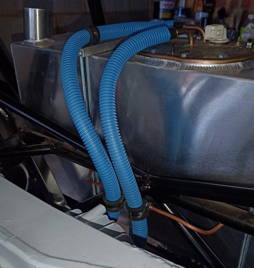 Image of flexible fuel line routing from tank towards fuel filter and rigid fuel lines