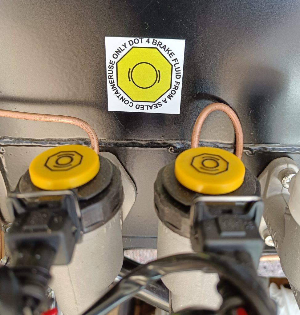 Image of first items to be fitted to the RX-5 - IVA compliant brake reservior caps and DOT4 sticker.