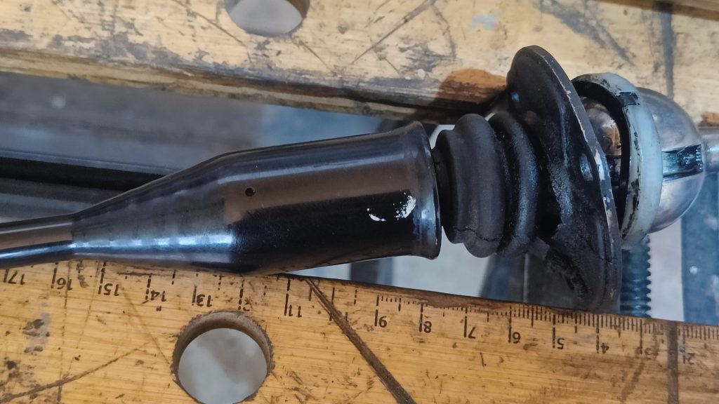 Image of original rubber shifter seal and upper bush ready for removal.