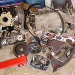Image of engine parts carefully boxed on the floor of the garage.