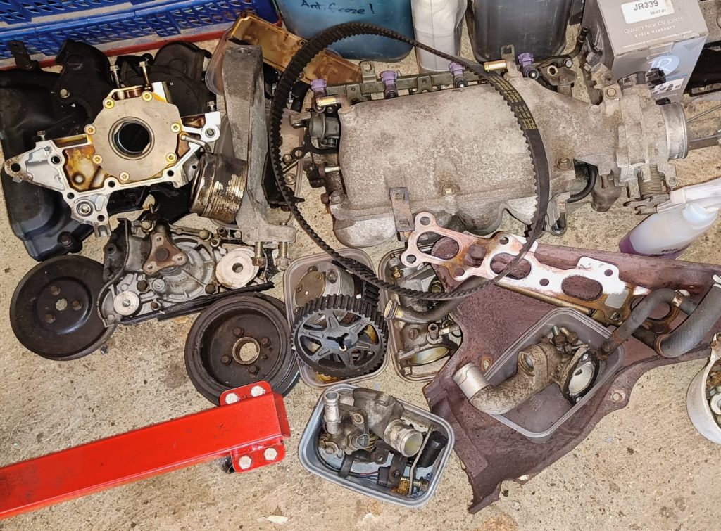 Image of engine parts carefully boxed on the floor of the garage.