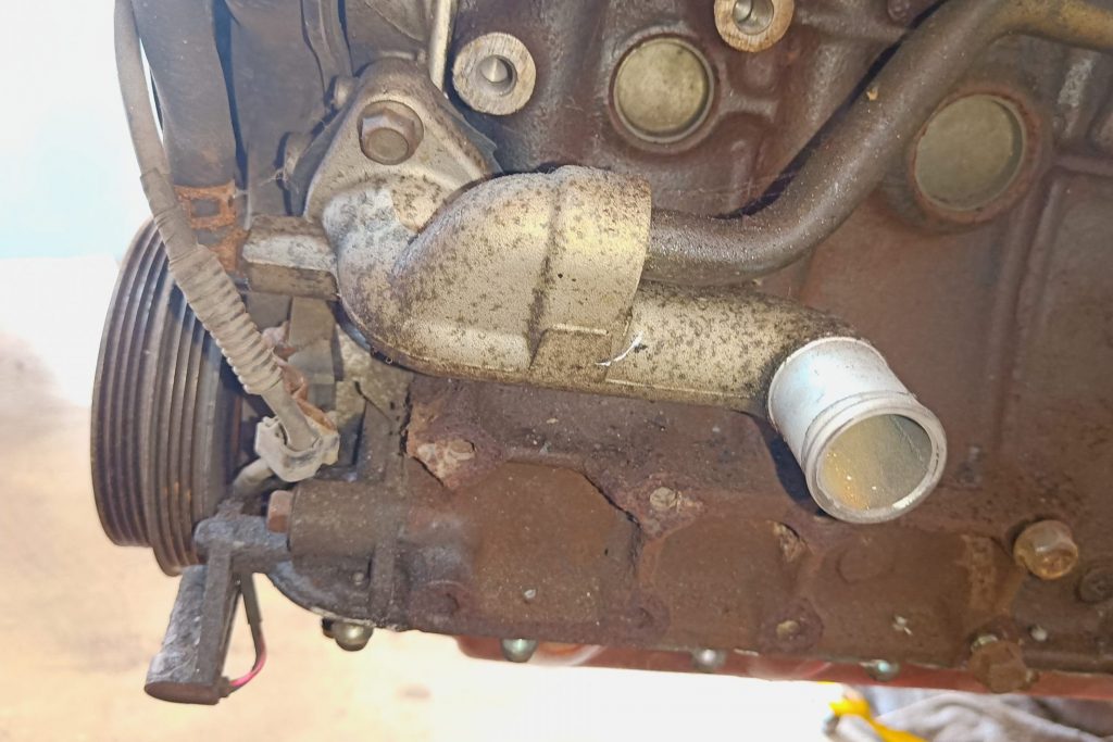 Image of LHS front of engine showing water mixer manifold & crank position sensor location.