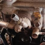 Image of rear of engine head showing water inlet and coolant temp gauge.