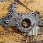 Image of oil pump removed to extricate a broken bolt and rusted in timing cover crush tubes.