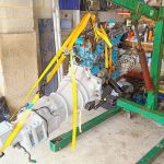 Image of engine and gearbox on hoist ready to be installed.