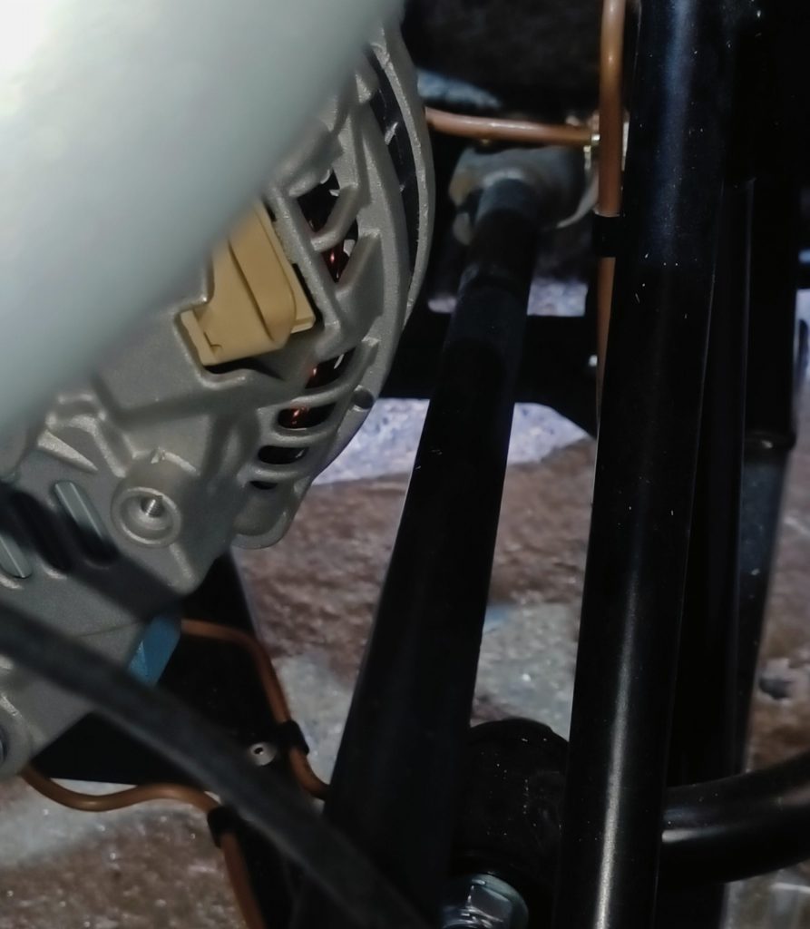 Image of steering column clearance after new engine mounts installed and various bits of alternator housing and a small area of oil pump had been ground down.